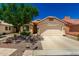 Beige single-story home with a two-car garage, desert landscaping, and a concrete driveway at 11669 W Pine Mountain Ct, Surprise, AZ 85378