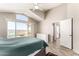 Bedroom with large window and vaulted ceiling showcasing outdoor views, a white dresser, and ensuite bath at 11669 W Pine Mountain Ct, Surprise, AZ 85378