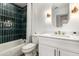 Bright bathroom featuring emerald tiled shower, modern vanity with gold fixtures, and a neutral color palette at 1710 S Aaron --, Mesa, AZ 85209