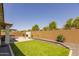 Manicured backyard with artificial grass, a fireplace, and space for entertaining at 17178 W Buchanan St, Goodyear, AZ 85338
