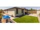 Artificial grass in backyard with an outdoor kitchen at 17178 W Buchanan St, Goodyear, AZ 85338
