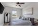 Comfortable bedroom featuring a large bed with plush pillows, ceiling fan, and natural light from the window at 17178 W Buchanan St, Goodyear, AZ 85338