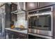 Gourmet kitchen with stainless steel appliances, gas cooktop, and stylish range hood at 17178 W Buchanan St, Goodyear, AZ 85338