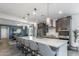 Large kitchen island with seating, modern appliances, pendant lighting, and dark cabinetry at 17178 W Buchanan St, Goodyear, AZ 85338