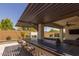 An outdoor kitchen with bar and grill, with a covered patio at 17178 W Buchanan St, Goodyear, AZ 85338