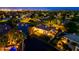 Breathtaking aerial view of the community showcasing lush greenery, waterways, and beautifully lit homes at night at 1724 W Blue Ridge Way, Chandler, AZ 85248