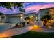 Stunning home exterior featuring an arched entryway, beautiful desert landscaping, and a two-car garage at sunset at 1724 W Blue Ridge Way, Chandler, AZ 85248