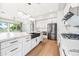 Bright kitchen boasts stainless steel appliances, white cabinetry, and a spacious island with a farmhouse sink at 1724 W Blue Ridge Way, Chandler, AZ 85248