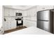 Modern white kitchen featuring stainless steel appliances, white cabinetry, and a stylish backsplash at 1800 W Shawnee Dr, Chandler, AZ 85224