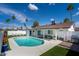 Inviting backyard oasis featuring a sparkling blue pool, green grass, lounging area, and palm trees at 1800 W Shawnee Dr, Chandler, AZ 85224