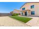 View of backyard with block fence, gravel, and faux grass area with covered patio at 18514 W Williams Rd, Surprise, AZ 85387