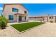 View of backyard with grass area, patio, fence, shed, and pavers surrounded by rocks at 18514 W Williams Rd, Surprise, AZ 85387