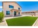 Backyard with grass area, patio, fence, pavers, and rocks under clear blue sky at 18514 W Williams Rd, Surprise, AZ 85387