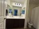 Bathroom features double sinks with modern vanity, white toilet, and shower at 18514 W Williams Rd, Surprise, AZ 85387