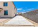 Long driveway leading up to a block wall with adjacent gravel landscaping and pavers at 18514 W Williams Rd, Surprise, AZ 85387