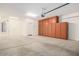 Spacious garage featuring built-in brown storage cabinets, a water heater, and a white door at 18514 W Williams Rd, Surprise, AZ 85387