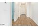 Bright hallway featuring wood-look floors and white trim at 18514 W Williams Rd, Surprise, AZ 85387