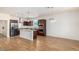Open kitchen with a large island, stainless steel appliances, and wood-look flooring at 18514 W Williams Rd, Surprise, AZ 85387
