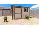 Outdoor shed in backyard with painted walls and trim, next to rock landscaping at 18514 W Williams Rd, Surprise, AZ 85387