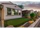Charming backyard with artificial grass, accent lighting, and a covered patio with views at 20784 W Minnezona Ave, Buckeye, AZ 85396