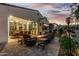 Beautiful outdoor living area with a cozy fire pit, dining table, and lush landscaping for relaxation and entertainment at 20784 W Minnezona Ave, Buckeye, AZ 85396