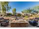 Relaxing backyard area with seating surrounding the cozy outdoor fire pit, great for entertaining friends at 20784 W Minnezona Ave, Buckeye, AZ 85396