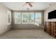 Spacious bedroom with neutral tones, ceiling fan, and large windows with shutter blinds at 20784 W Minnezona Ave, Buckeye, AZ 85396