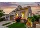 Attractive home with a tiled roof, two-car garage, and vibrant landscaping under a dusky sky at 20784 W Minnezona Ave, Buckeye, AZ 85396