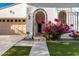 Charming home entrance with beautiful desert landscaping and a decorative arched entryway at 20784 W Minnezona Ave, Buckeye, AZ 85396