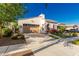 Charming home featuring an arched entryway, two-car garage, well-manicured landscaping, and beautiful bougainvillea at 20784 W Minnezona Ave, Buckeye, AZ 85396