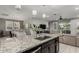An open kitchen features a stylish island with granite countertops overlooking the dining and living areas at 20784 W Minnezona Ave, Buckeye, AZ 85396