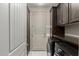 Laundry room with dark cabinetry, new appliances, and a functional design at 20784 W Minnezona Ave, Buckeye, AZ 85396