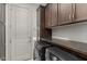 Convenient laundry room featuring dark cabinetry, a washer and dryer, and ample storage at 20784 W Minnezona Ave, Buckeye, AZ 85396