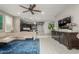 Open-concept living area with tile flooring, modern furniture, and seamless flow to the kitchen at 20784 W Minnezona Ave, Buckeye, AZ 85396