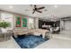 Open-concept living room with plush seating, modern decor, and seamless transition to the kitchen and dining area at 20784 W Minnezona Ave, Buckeye, AZ 85396