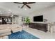 Spacious living area with a comfortable sofa, a large TV, and a view of the dining area and kitchen at 20784 W Minnezona Ave, Buckeye, AZ 85396