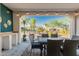 Covered patio featuring outdoor dining set and view of the backyard's landscaping and fire pit area at 20784 W Minnezona Ave, Buckeye, AZ 85396