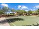 A green basketball court on a sunny day is set within trees, with single Gathering homes in the background at 2562 N Springfield St, Buckeye, AZ 85396