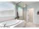 A modern bathroom features a soaking tub, walk-in shower, and bright natural light at 2562 N Springfield St, Buckeye, AZ 85396
