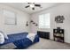 Bedroom featuring a ceiling fan, window, shelves and a blue comforter on the bed at 2562 N Springfield St, Buckeye, AZ 85396