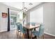 Bright dining room with wood-look tile flooring, contemporary lighting, and a sliding glass door to patio at 2562 N Springfield St, Buckeye, AZ 85396