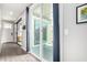 Bright hallway featuring wood-look flooring and access to a sliding glass door to the outdoor patio at 2562 N Springfield St, Buckeye, AZ 85396