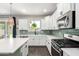 Well-lit kitchen with white cabinetry, stainless steel appliances, stylish backsplash, and quartz countertops at 2562 N Springfield St, Buckeye, AZ 85396