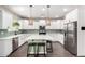 Modern kitchen with white cabinets, stainless steel appliances, large island, and stylish pendant lighting at 2562 N Springfield St, Buckeye, AZ 85396