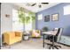 Bright home office featuring pops of blue and yellow, hanging plants and a desk at 2562 N Springfield St, Buckeye, AZ 85396