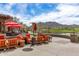 A sunny outdoor restaurant patio with mountain views features red umbrellas, patio furniture and views of a pond at 2562 N Springfield St, Buckeye, AZ 85396