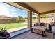 Covered patio with outdoor seating, ceiling fan, and a view of the spacious, well-maintained backyard at 2562 N Springfield St, Buckeye, AZ 85396
