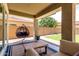 Relaxing covered patio with comfortable seating, pendant chair and view to manicured backyard at 2562 N Springfield St, Buckeye, AZ 85396