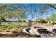 A quaint neighborhood park and playground are visible across a grass lawn from a shaded picnic area at 2562 N Springfield St, Buckeye, AZ 85396
