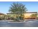 Landscaped community entrance with a mature tree, desert plants, and wrought-iron gates at 27000 N Alma School Pkwy # 1033, Scottsdale, AZ 85262